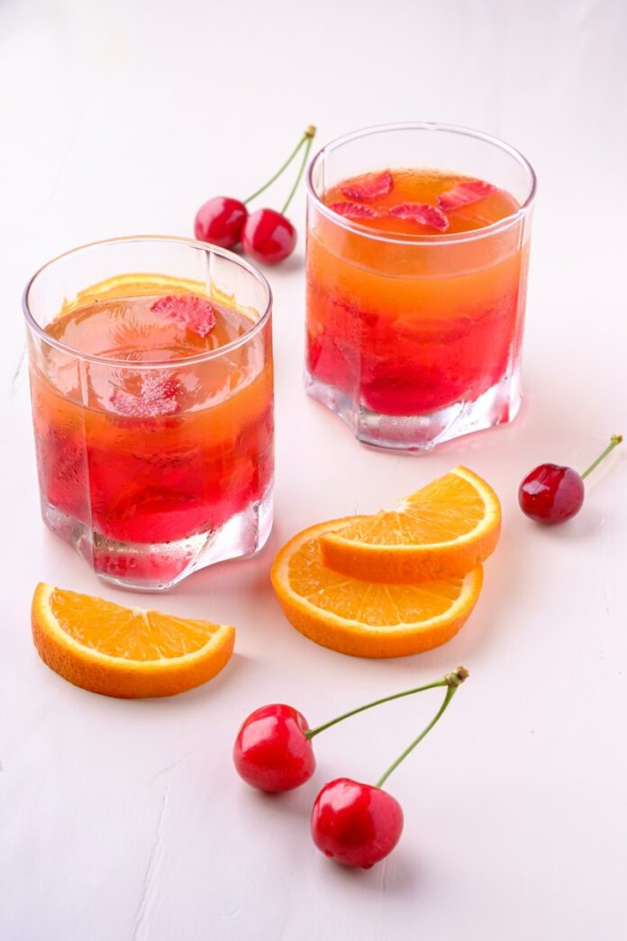 Photo by Rodion Kutsaiev two orange and cherry drink in glasses
