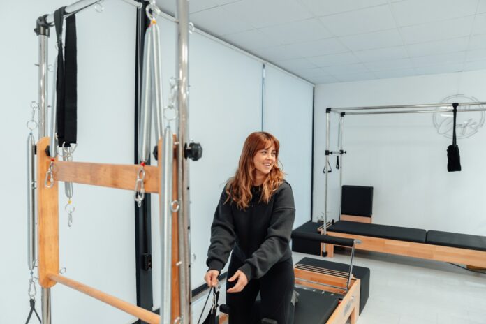 Photo by Ahmet Kurt a woman standing in a gym holding a bar