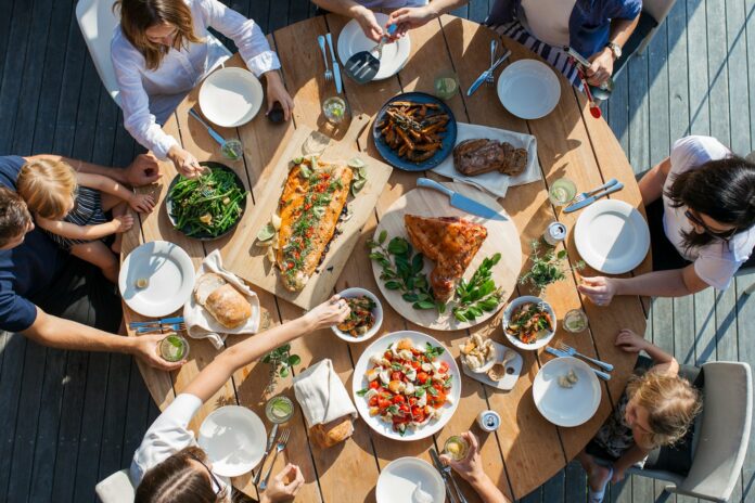 Photo by Luisa Brimble people eating on table with foods