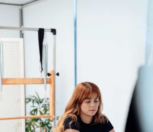 필라테스로 건강관리 하는 법 a woman on a rowing machine in a gym
