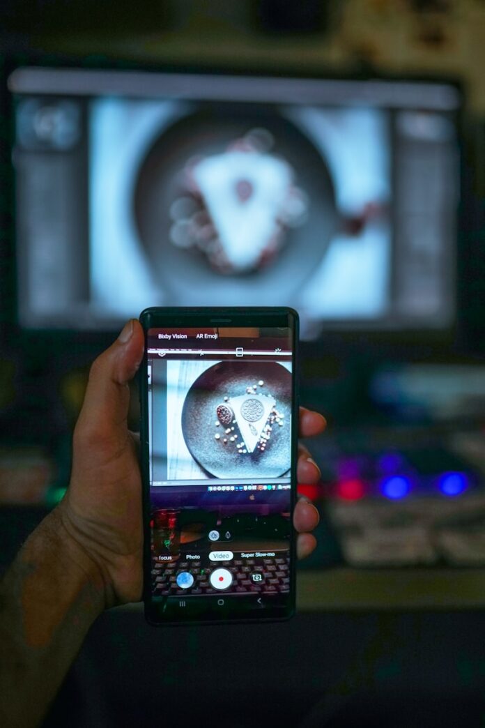 Photo by Zakaria Zayane a person holding a cell phone in front of a tv