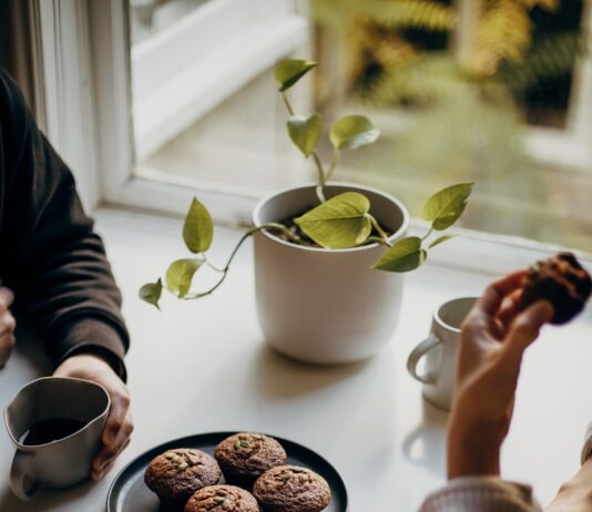 최근 부상한 ‘마음 챙김 식사’… 건강하게 먹는 새로운 습관 person holding brown and black round food on white ceramic plate
