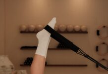 “집콕 시대의 건강 비결, 필라테스가 주목받는 이유와 실천법” Woman does pilates exercise on a reformer machine.